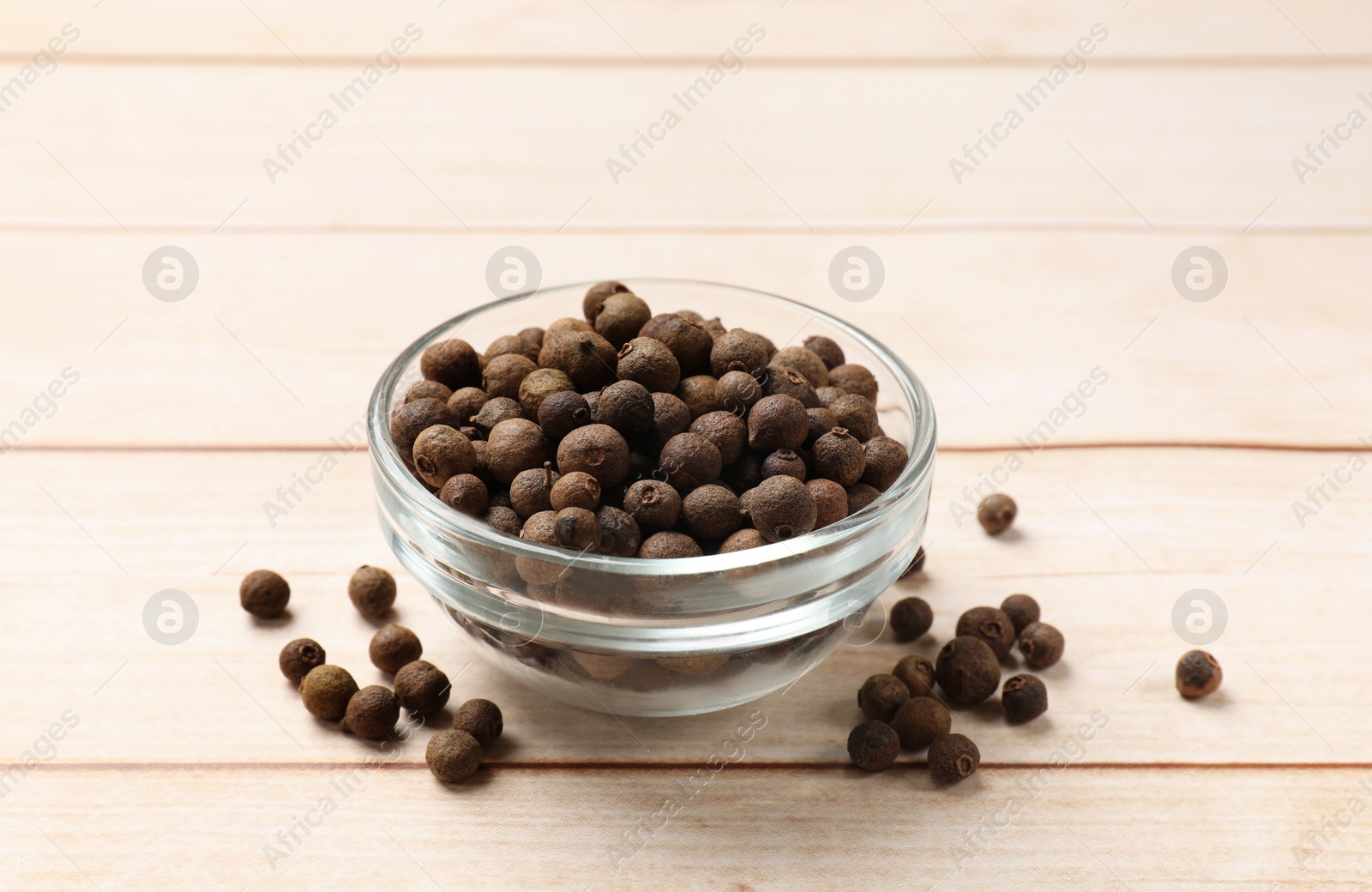 Photo of Dry allspice berries (Jamaica pepper) in bowl on light wooden table
