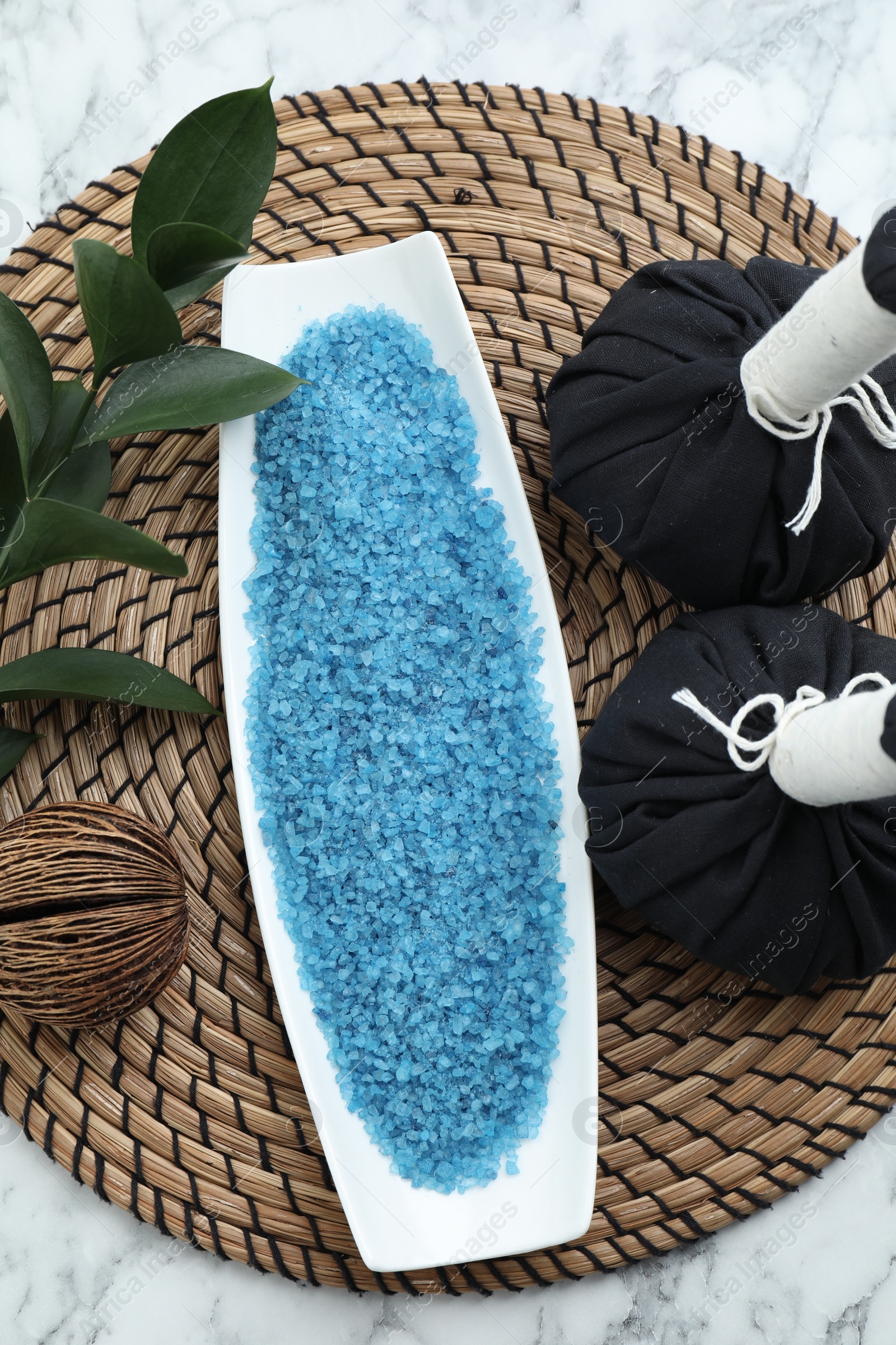 Photo of Composition with blue sea salt and herbal bags on white marble table, top view