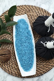 Photo of Composition with blue sea salt and herbal bags on white marble table, top view
