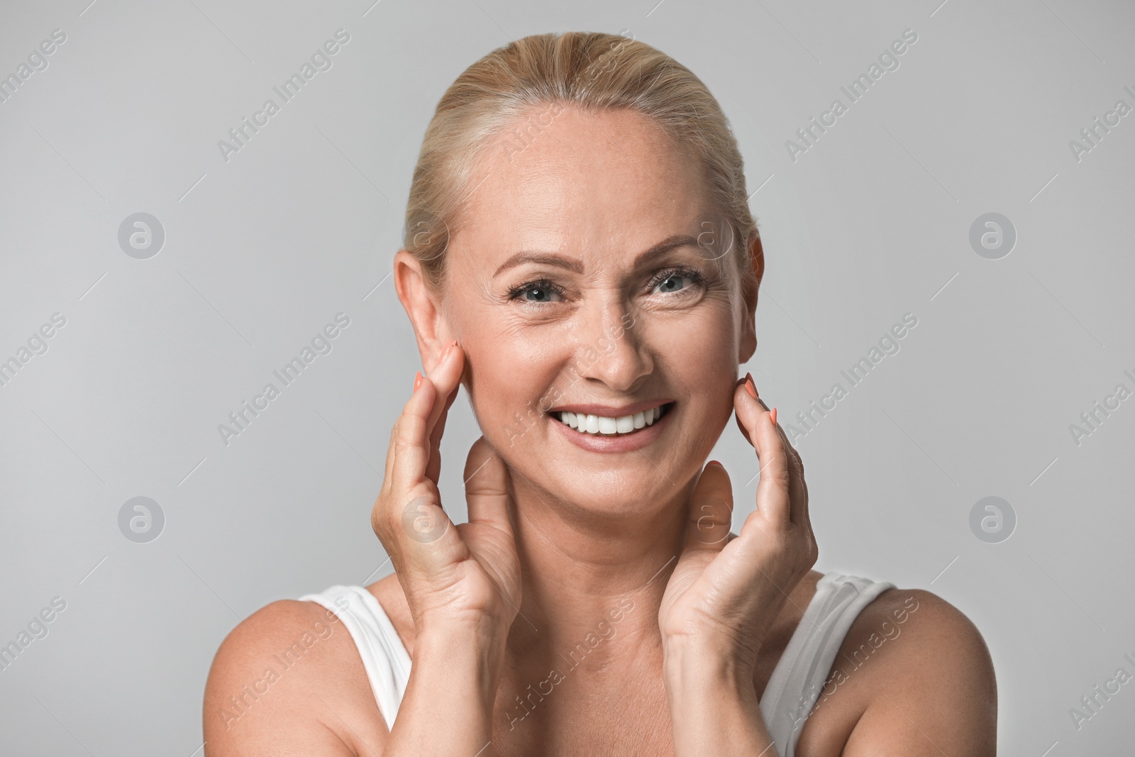 Photo of Portrait of beautiful mature woman with perfect skin on grey background