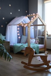 Stylish child room interior with house bed and different toys