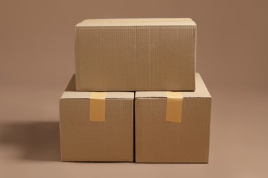 Stack of cardboard boxes on light brown background