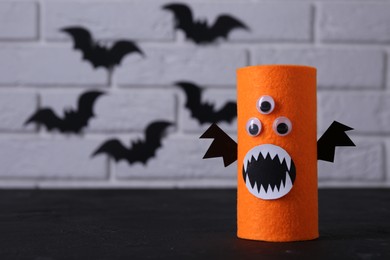 Photo of Spooky monster on black table, space for text. Handmade Halloween decoration