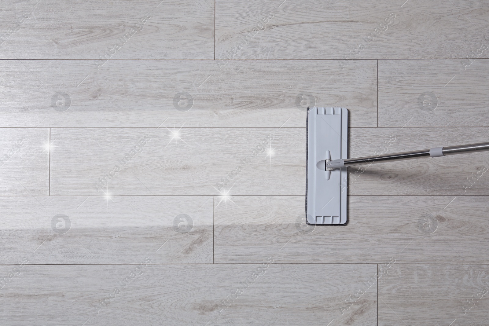 Image of Washing floor with mop indoors, top view. Clean and shiny trace on dirty surface