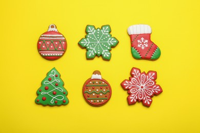 Photo of Different tasty Christmas cookies on yellow background, flat lay