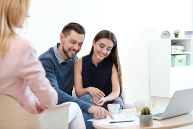 Female real estate agent working with couple in office