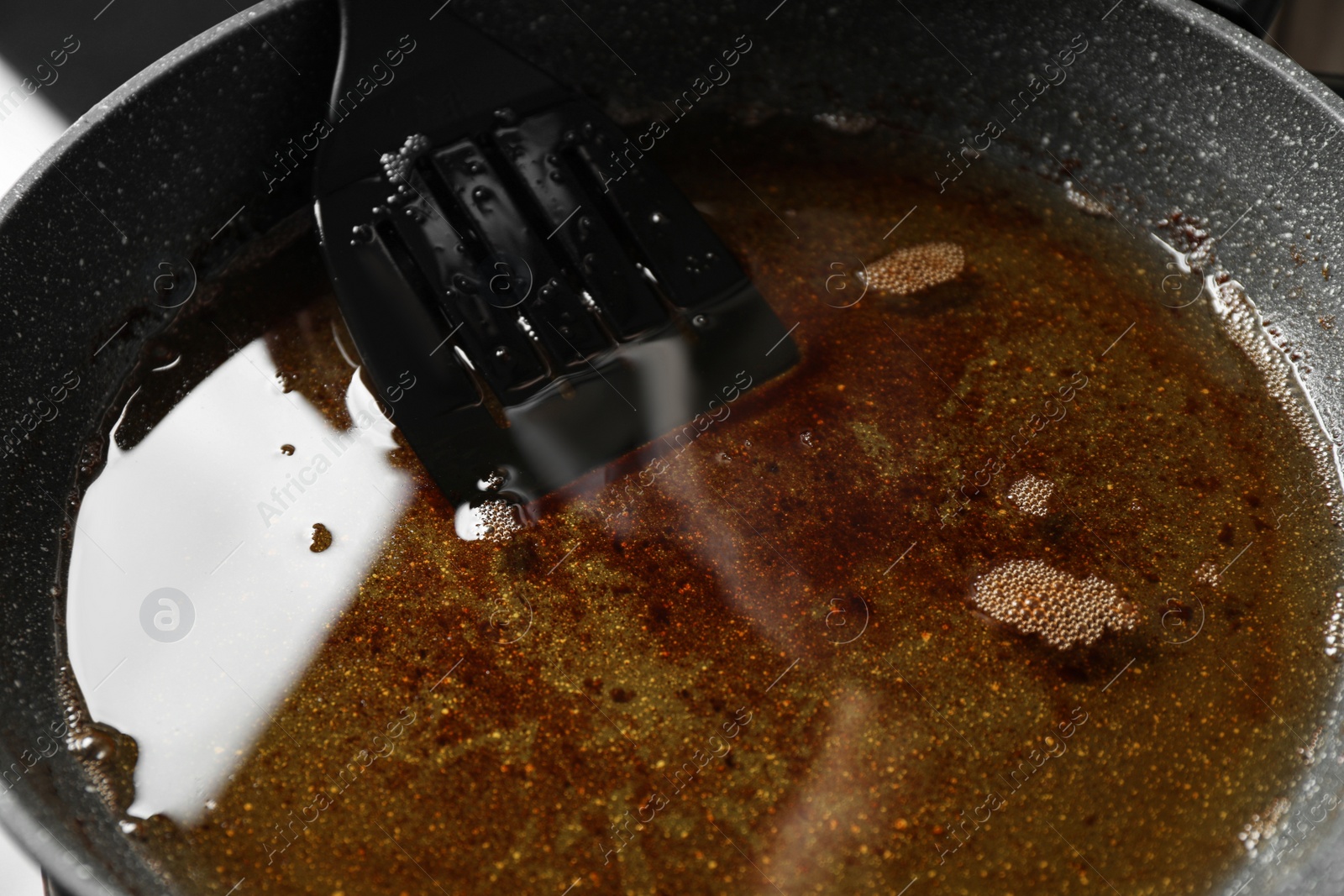 Photo of Used cooking oil in frying pan, closeup