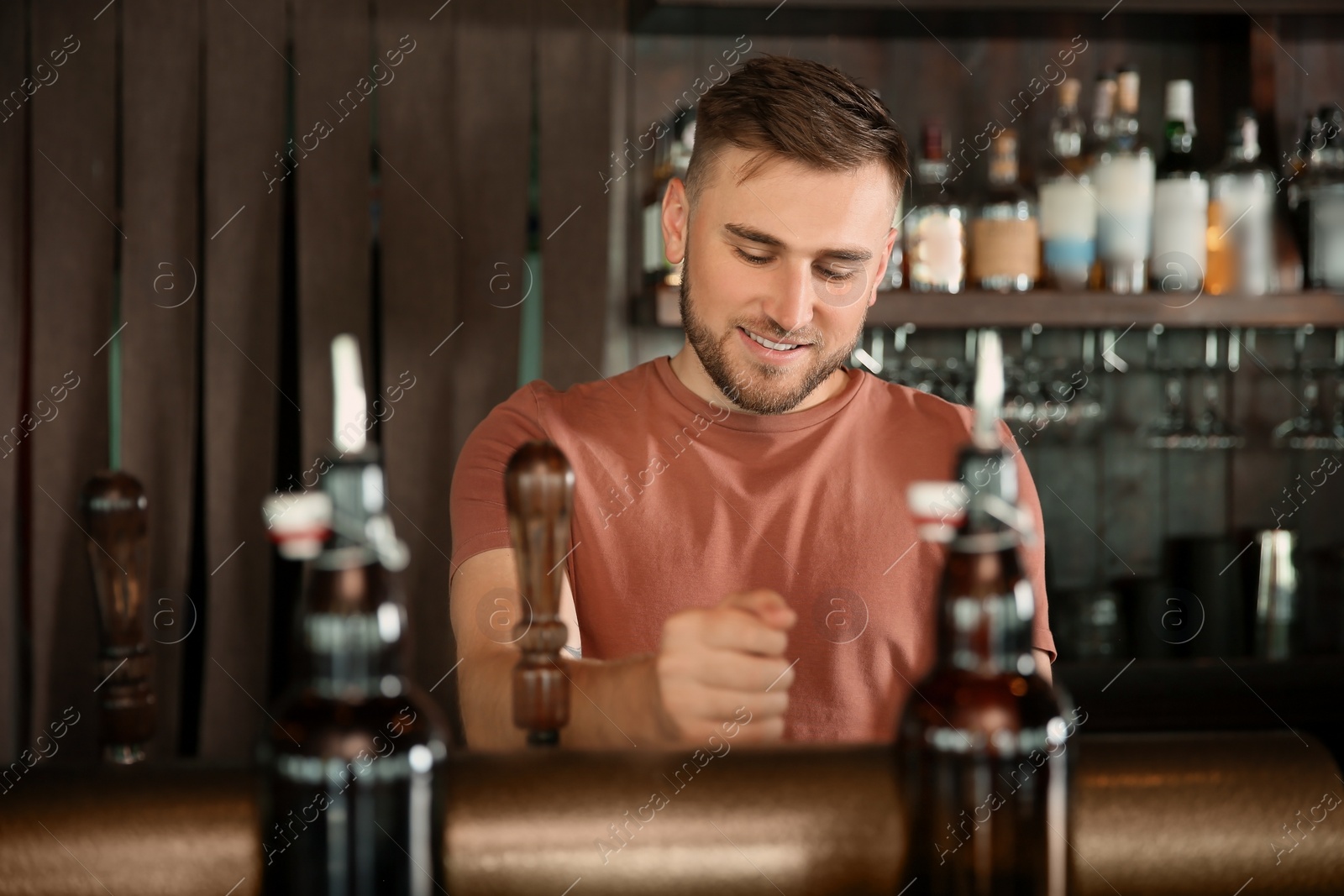 Photo of Bartender working at beer tap in pub