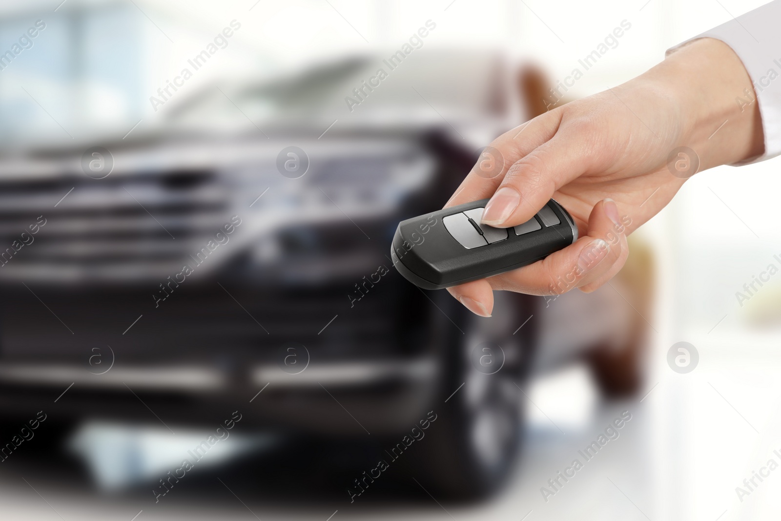 Image of Woman with key near new automobile indoors, closeup