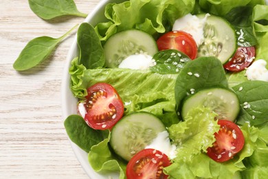 Photo of Delicious salad on white wooden table, closeup. Space for text