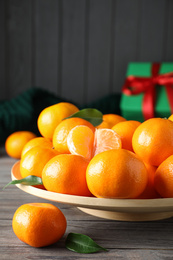 Photo of Tasty fresh tangerines on wooden table. Christmas celebration