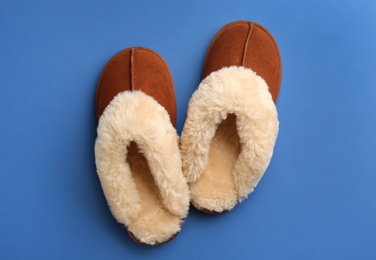 Photo of Pair of stylish soft slippers on blue background, flat lay