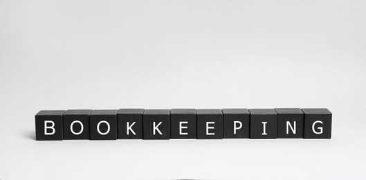 Photo of Word Bookkeeping made with black cubes on white background
