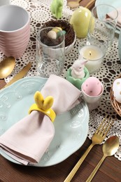 Photo of Festive table setting with napkin ring in shape of bunny ears, closeup. Easter celebration