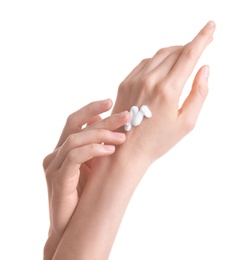 Young woman applying hand cream against on white background