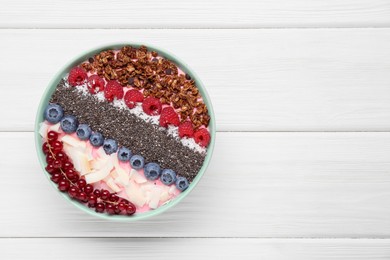 Photo of Tasty smoothie bowl with fresh berries and granola on white wooden table, top view. Space for text