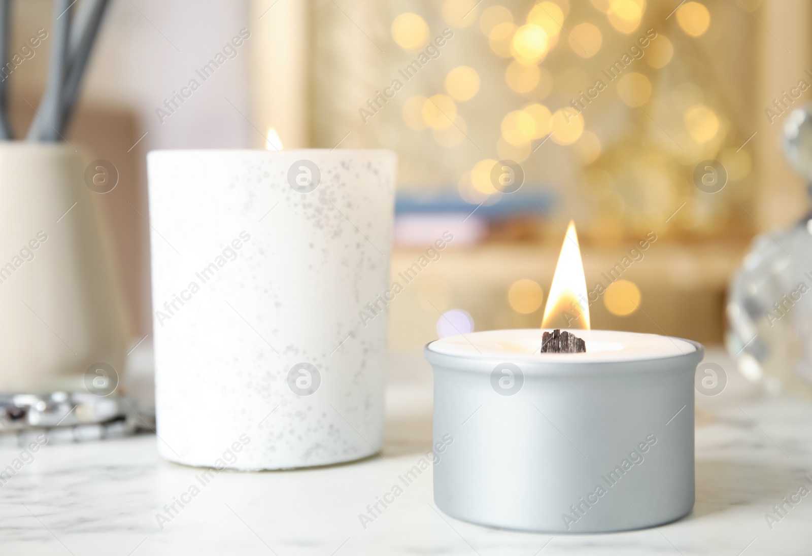 Photo of Burning candles in holders on white table