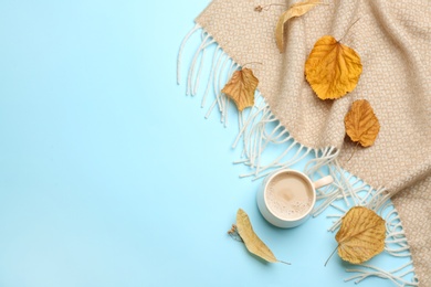 Photo of Flat lay composition with coffee and warm plaid on light blue background, space for text