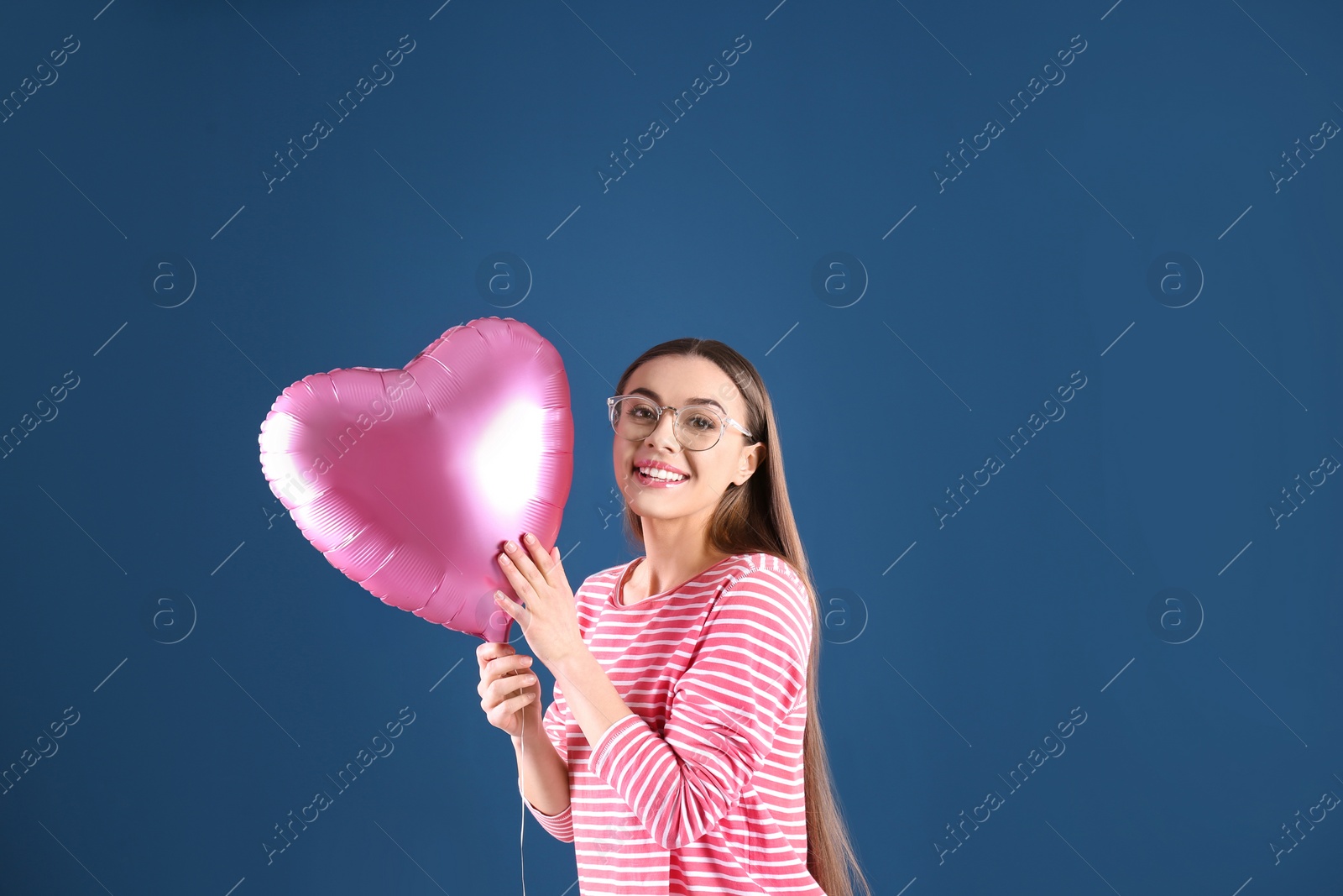 Photo of Portrait of young woman with heart shaped balloon on color background. Space for text