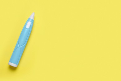 Photo of Stylish 3D pen on yellow background, top view. Space for text
