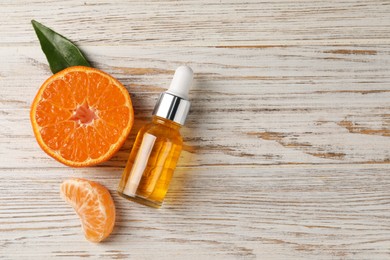 Bottle of tangerine essential oil and fresh fruit on white wooden table, flat lay. Space for text