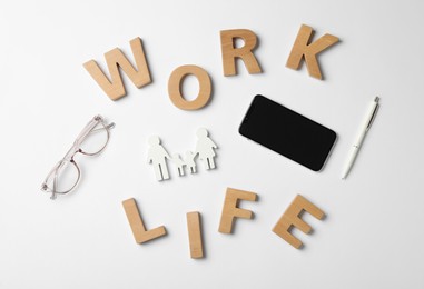 Words Work, Life made with wooden letters, smartphone and eyeglasses on white background, flat lay.  Balance concept