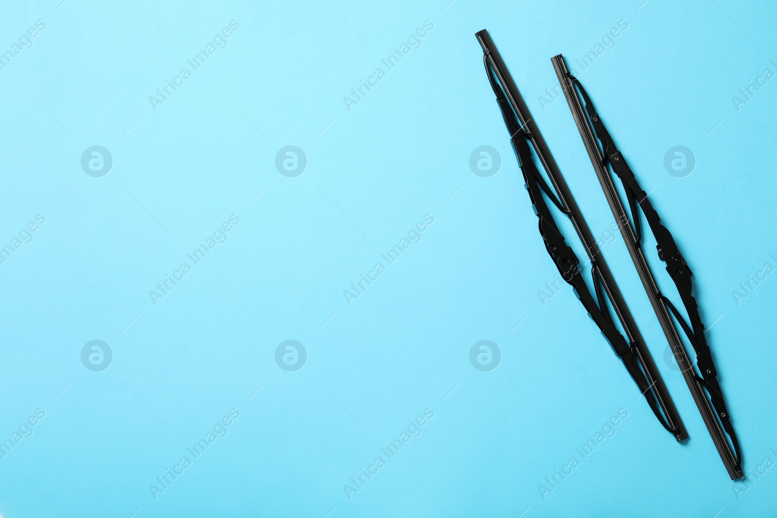 Photo of Car windshield wipers on light blue background, flat lay. Space for text