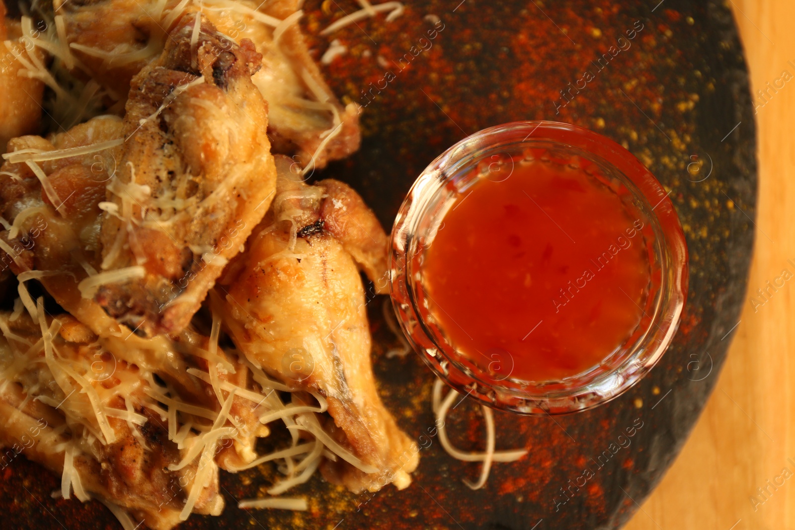 Photo of Tasty BBQ wings with red sauce served on table in cafe, top view