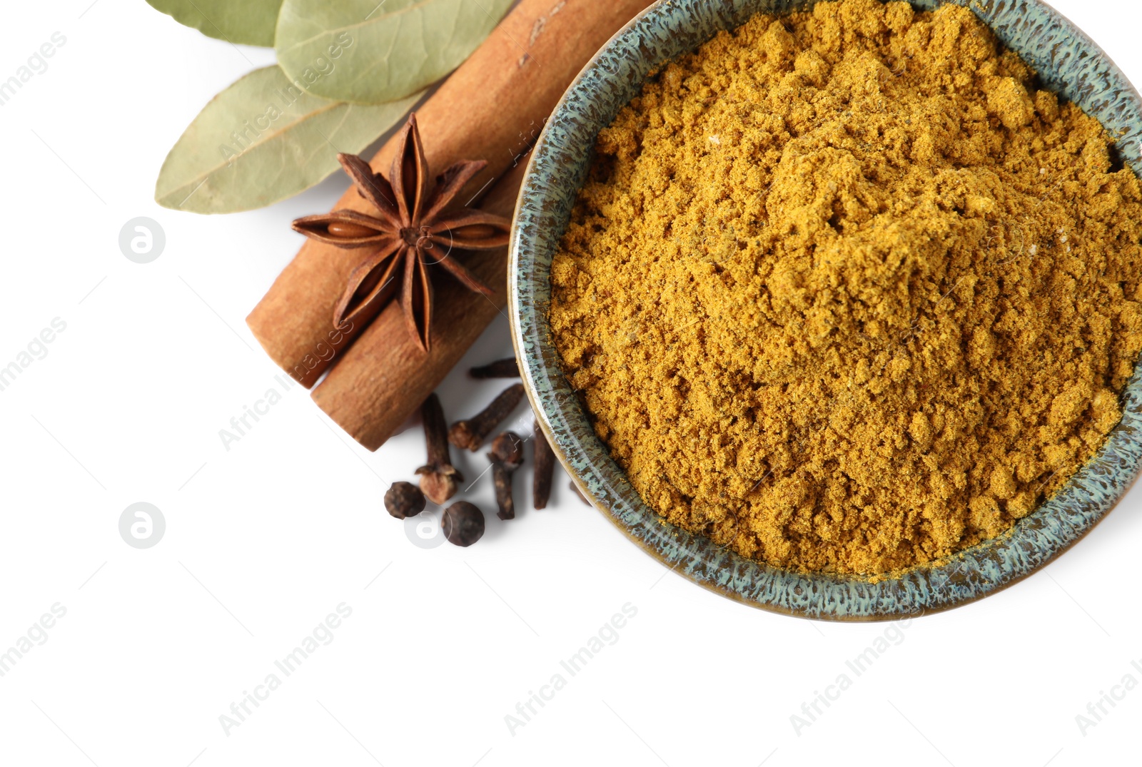 Photo of Dry curry powder in bowl and other spices isolated on white, top view