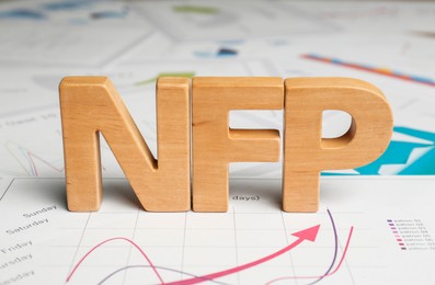 Photo of Wooden letters NFP on documents with charts