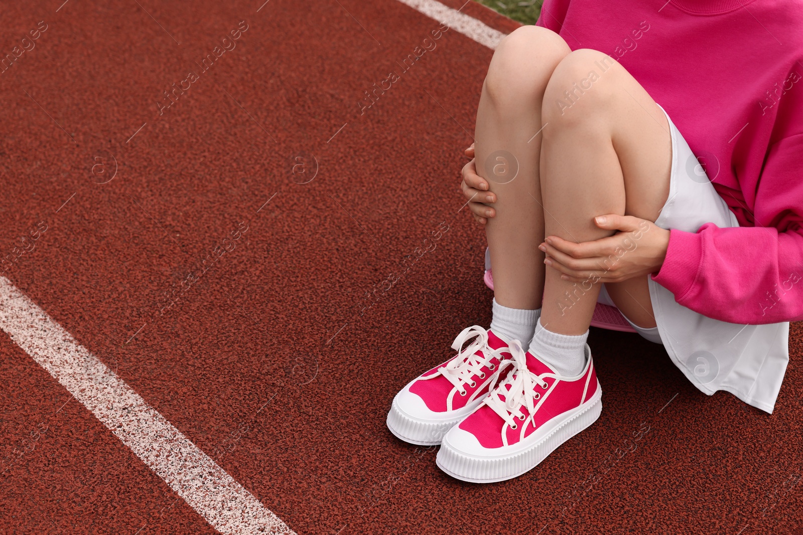 Photo of Woman wearing classic old school sneakers on sport court outdoors, closeup. Space for text