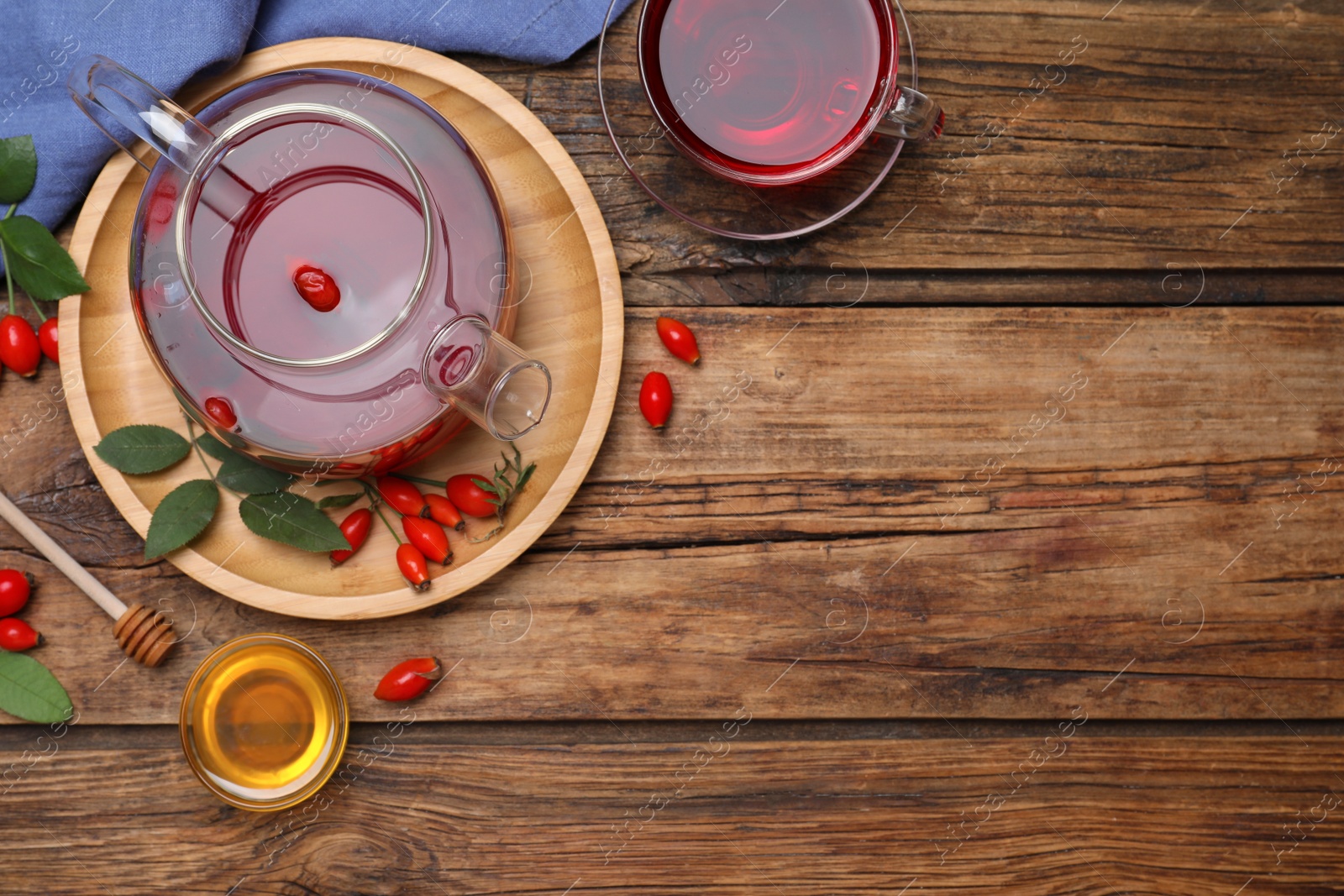 Photo of Flat lay composition with aromatic rose hip tea on wooden table. Space for text