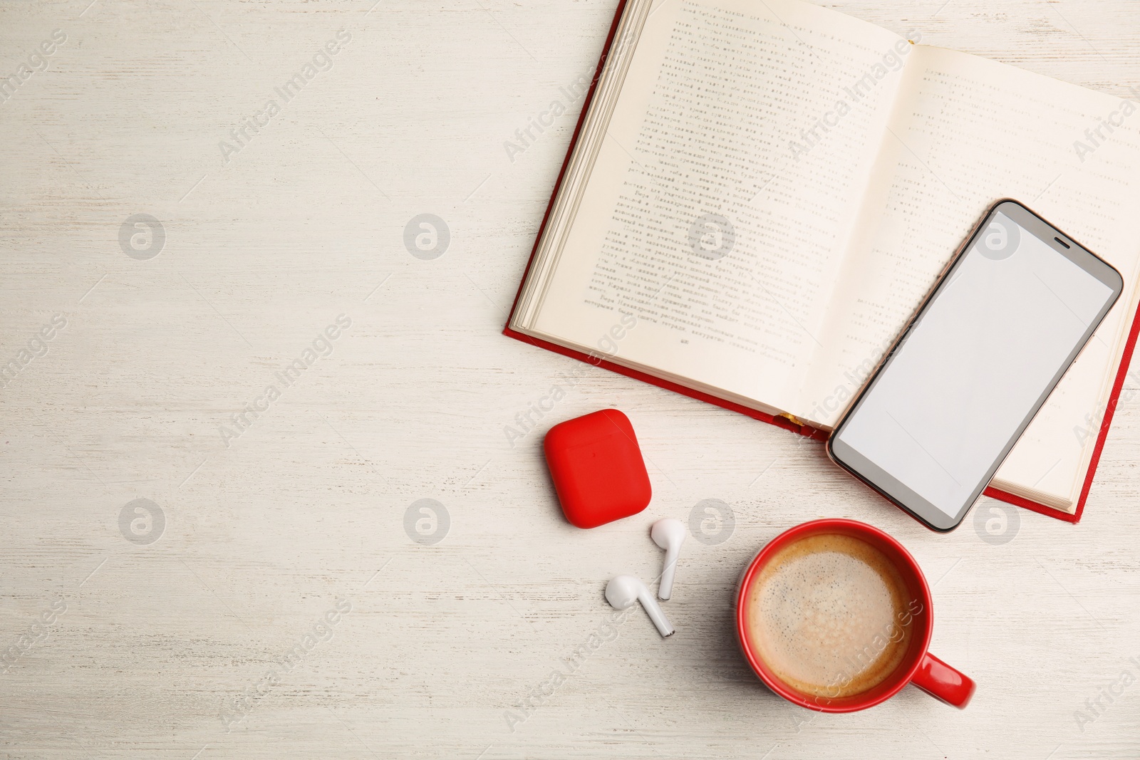 Photo of Book, coffee, earphones and mobile phone on white wooden table, flat lay. Space for text