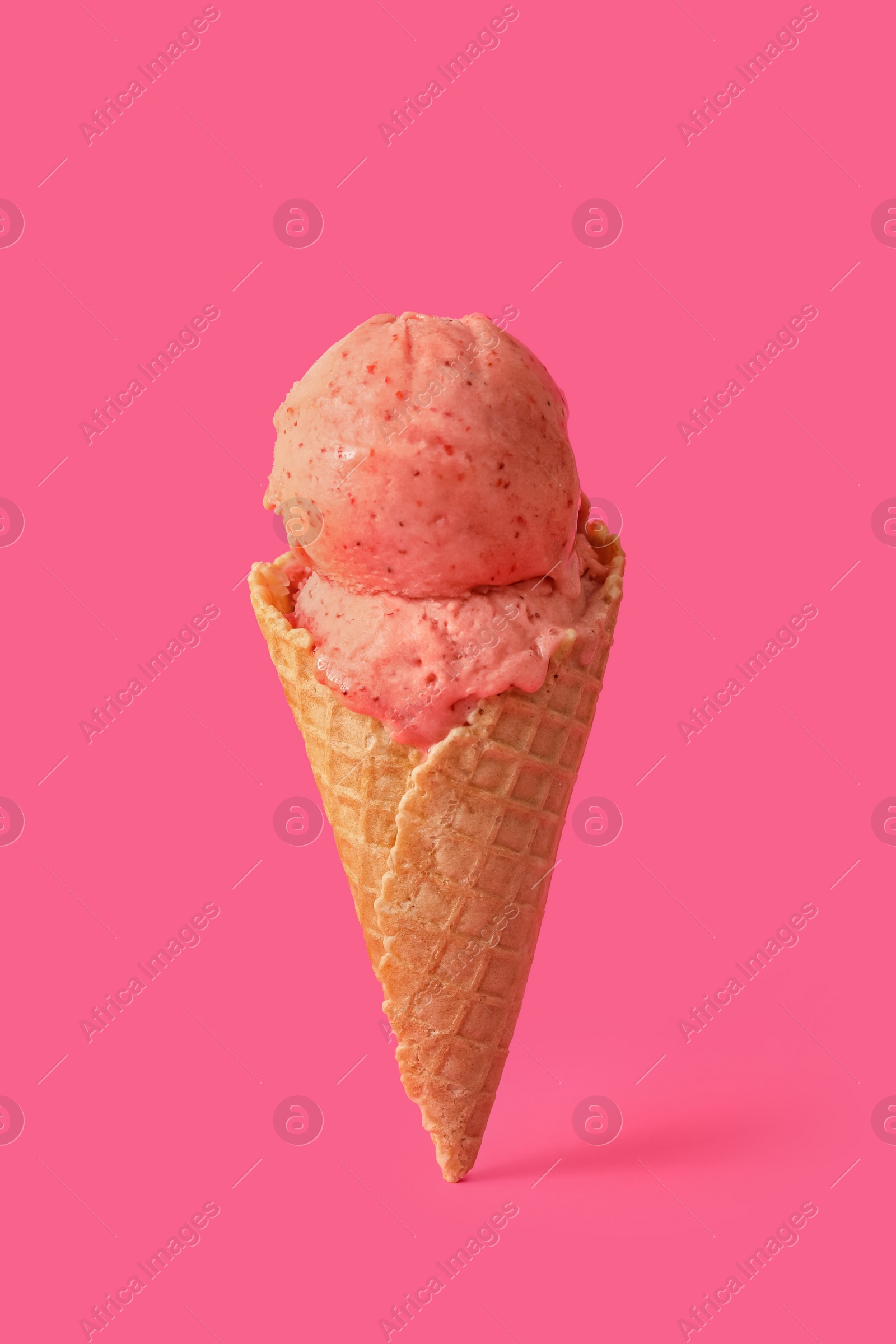 Photo of Delicious ice cream in waffle cone on pink background