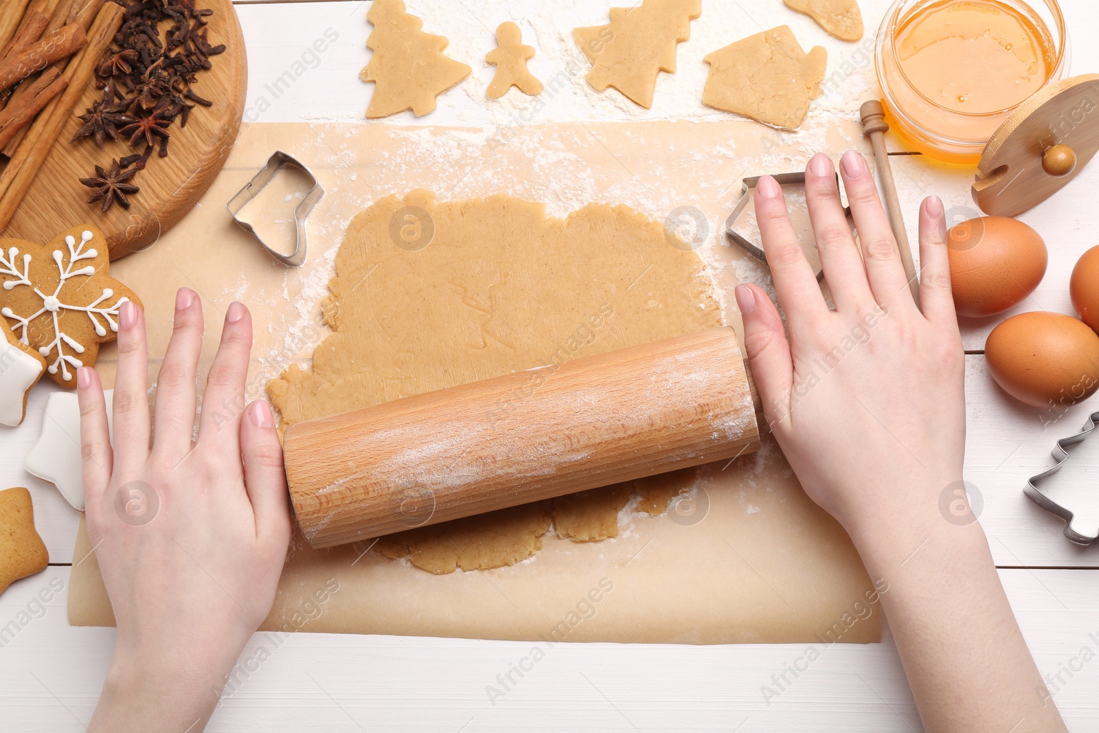 Photo of Making Christmas cookies. Woman rolling raw dough at white wooden table, top view