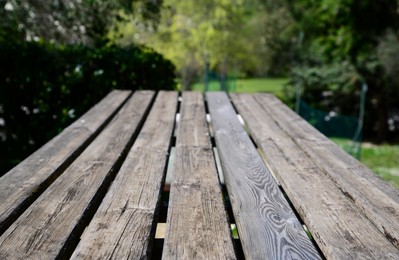 Photo of Empty wooden table in park on sunny day, closeup