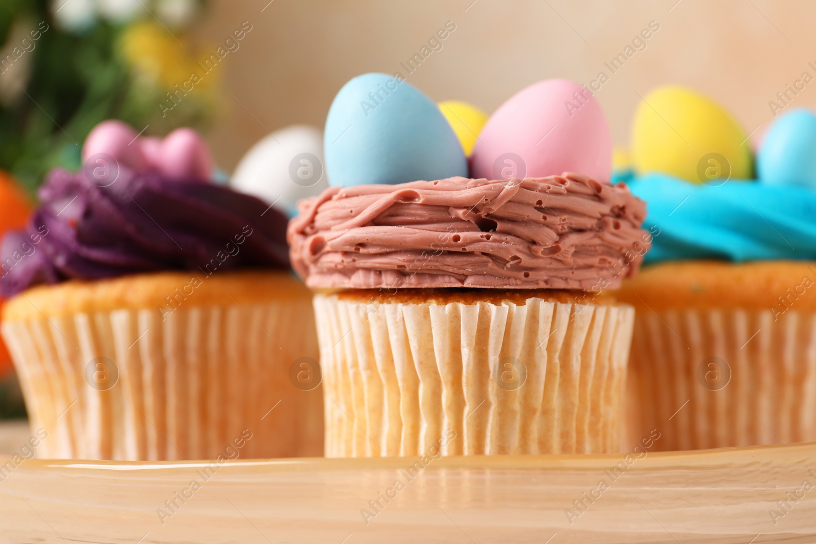 Photo of Tasty decorated Easter cupcakes on stand, closeup