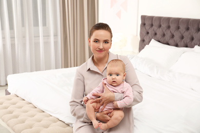 Photo of Young woman and her little baby at home