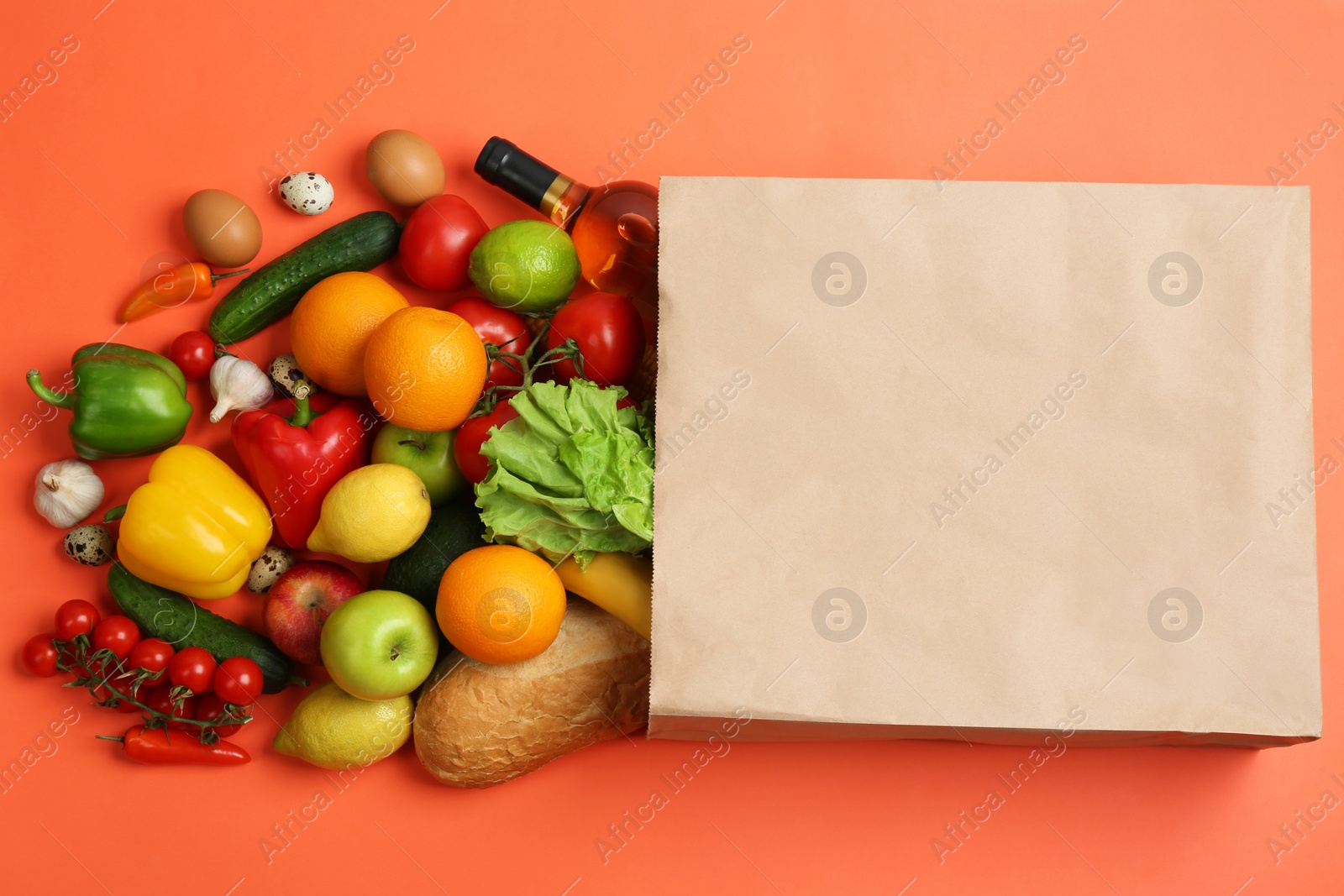 Photo of Paper bag with different groceries on coral background, flat lay