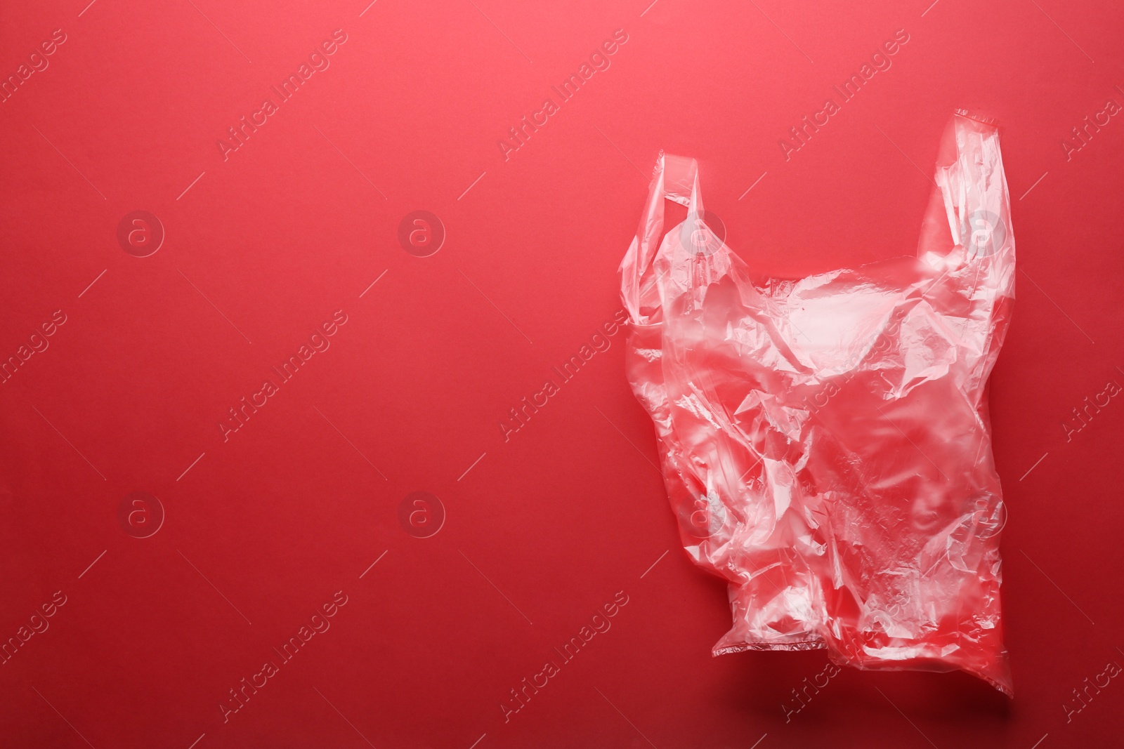 Photo of Clear disposable plastic bag on color background. Space for text