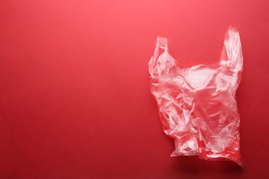 Photo of Clear disposable plastic bag on color background. Space for text