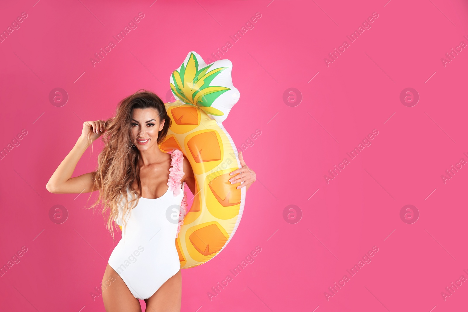 Photo of Pretty sexy woman in stylish bikini with inflatable ring on color background, space for text