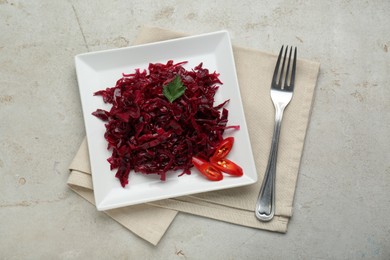 Photo of Tasty red cabbage sauerkraut with chili pepper and parsley served on light grey table, flat lay