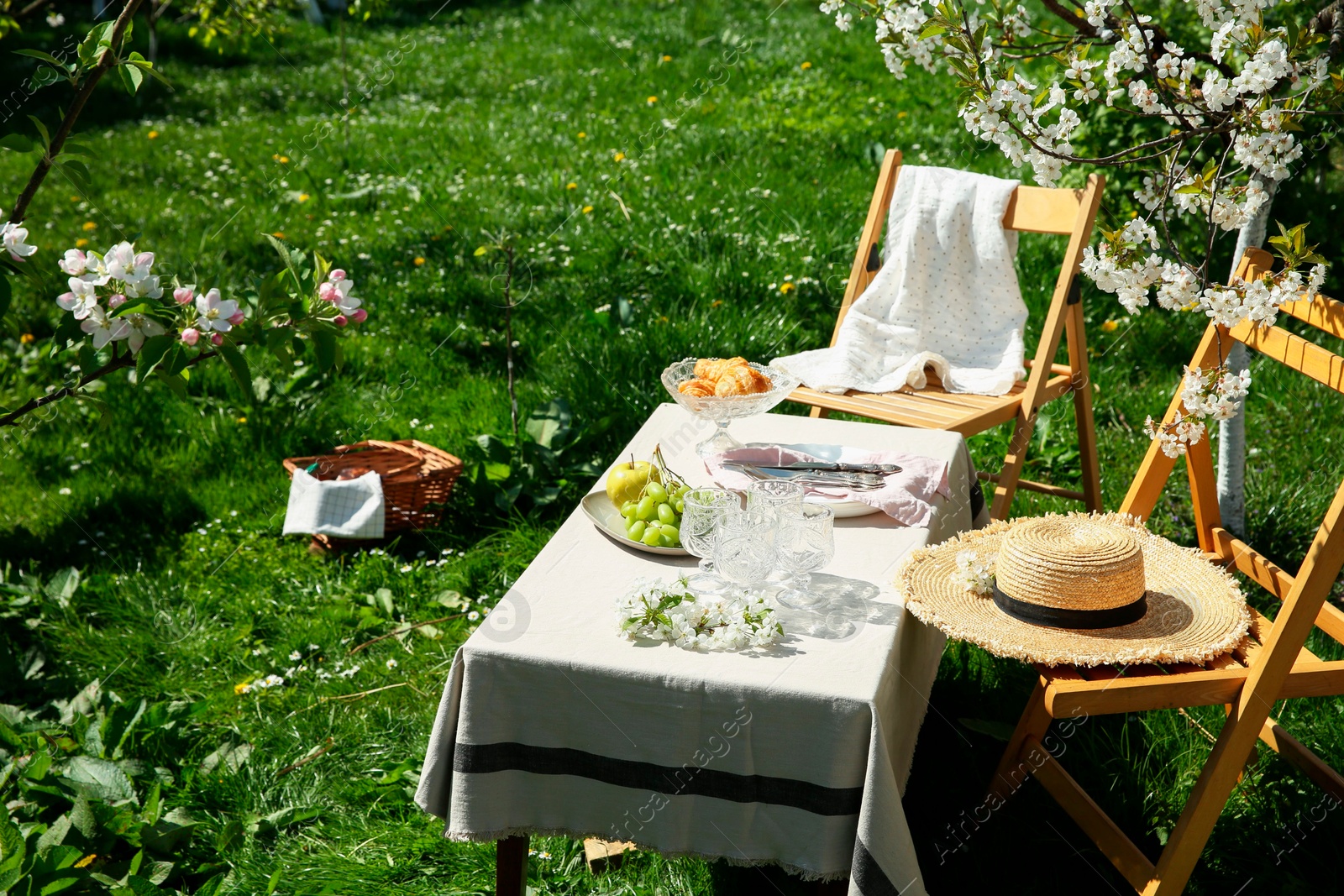 Photo of Stylish table setting with beautiful spring flowers in garden on sunny day