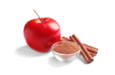 Photo of Fresh apple with cinnamon sticks and powder on white background