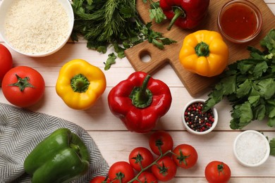 Making stuffed peppers. Rice and other ingredients on white wooden table, flat lay