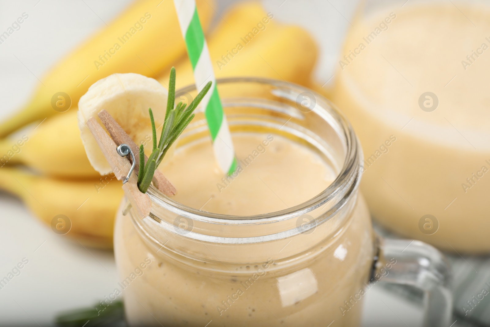 Photo of Mason jar of tasty banana smoothie with straw, closeup