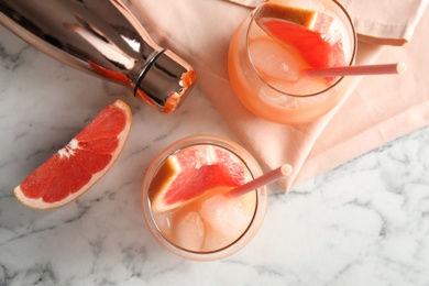 Photo of Flat lay composition with glasses of grapefruit cocktails on marble background