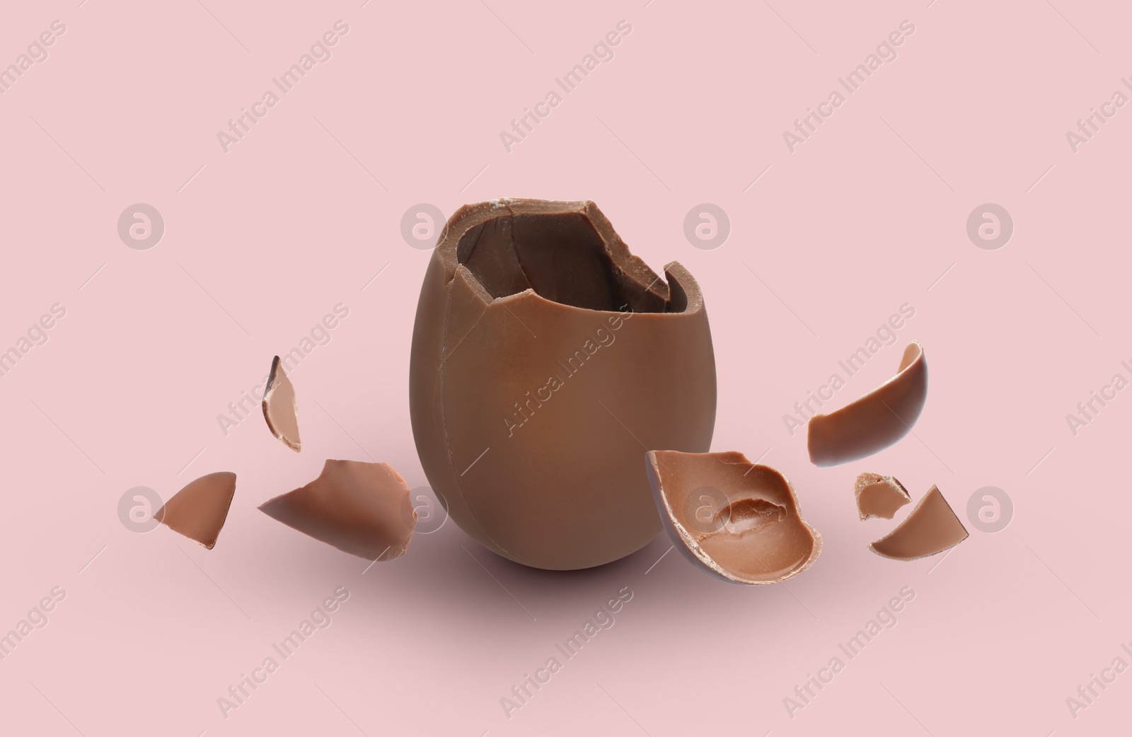 Image of Exploded milk chocolate egg on pale pink background