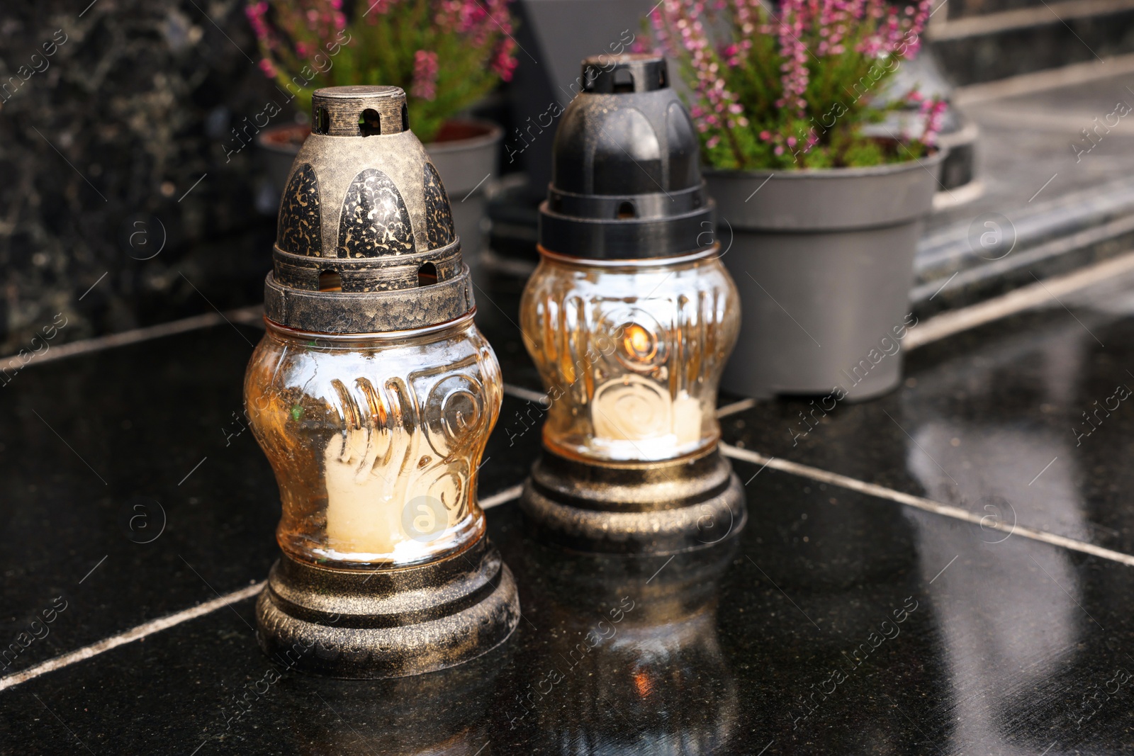 Photo of Grave lanterns on black tiled surface at cemetery